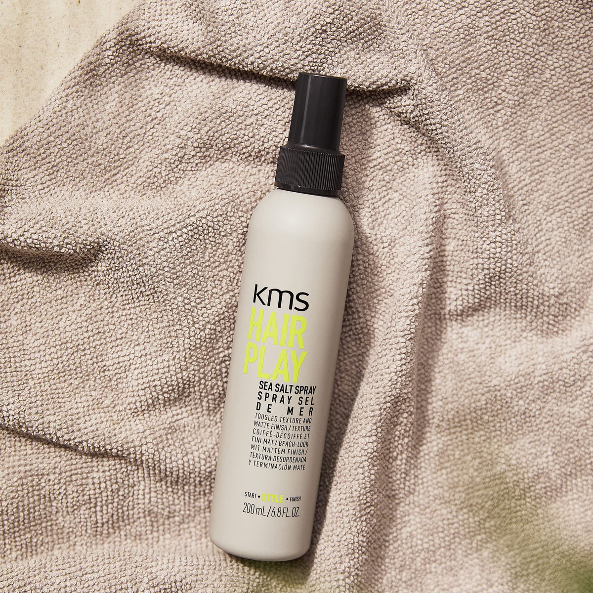 KMS HAIRPLAY held in hand to show 6.7 oz size and travel-friendly benefit