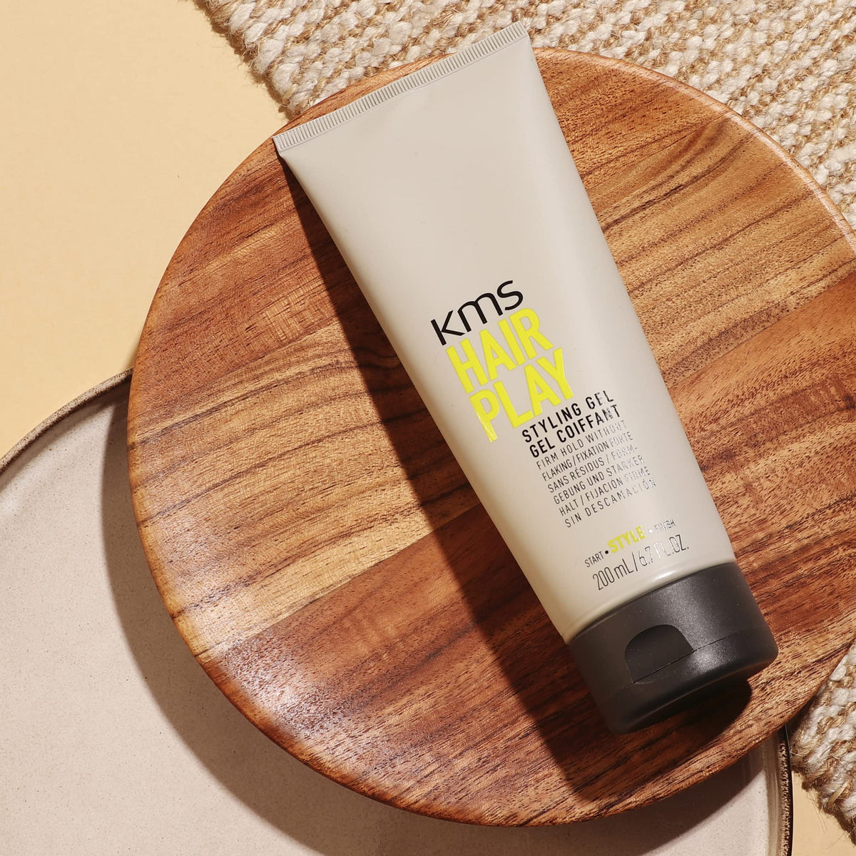 KMS 200ml size comparison next to hand to show compact travel-friendly volume