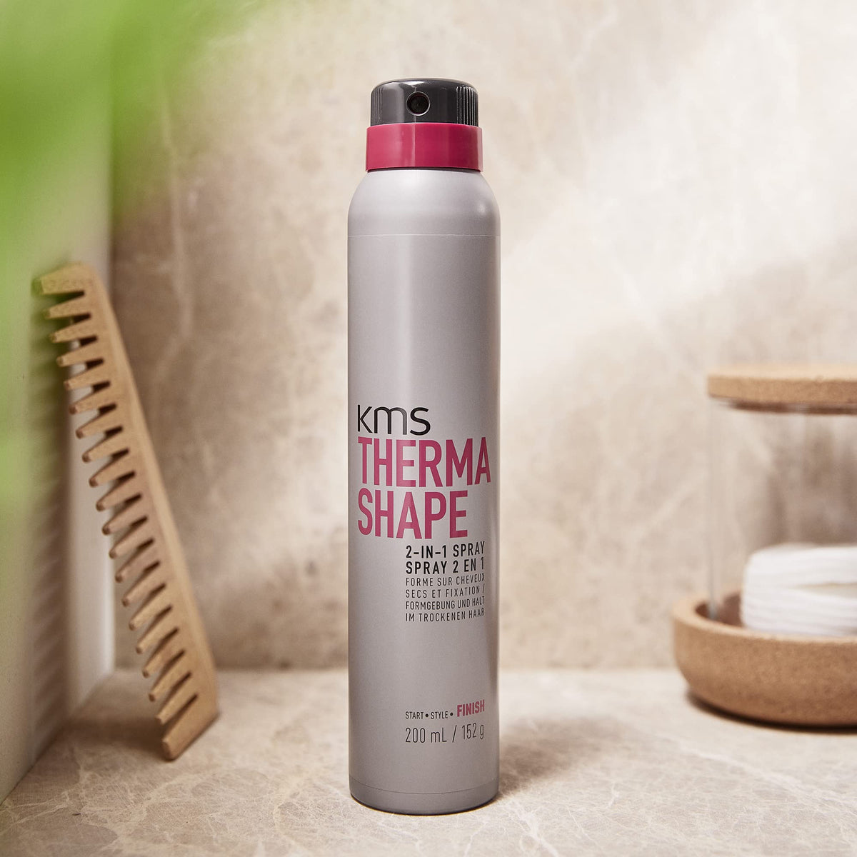 KMS THERMASHAPE bottle in hand for size comparison and easy travel-friendly benefit