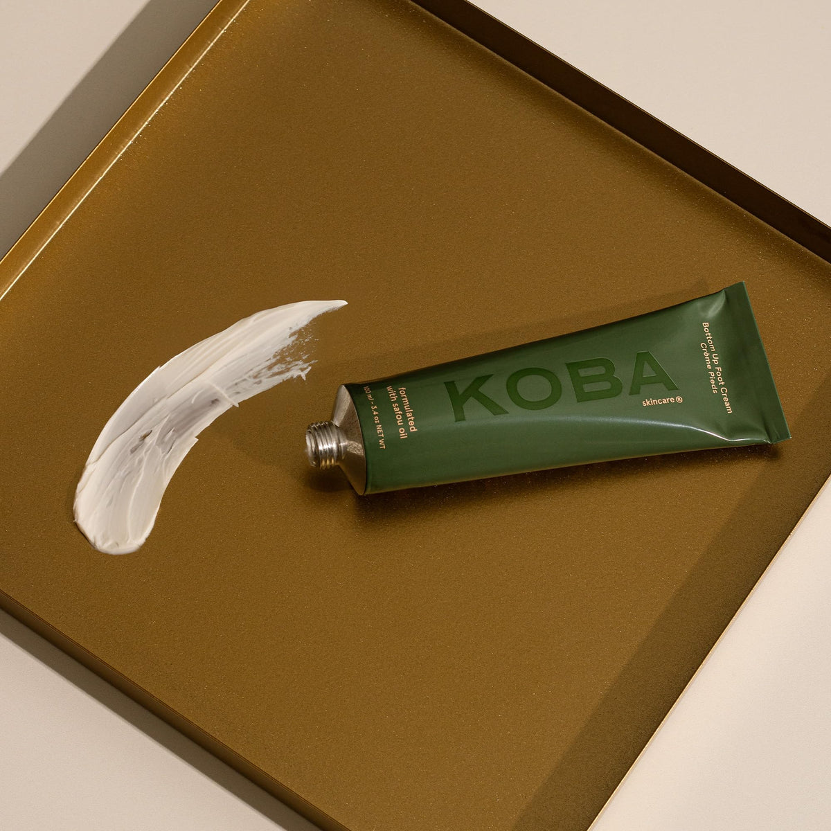 KOBA being applied to feet in hand illustrating smooth glide and quick absorption benefit