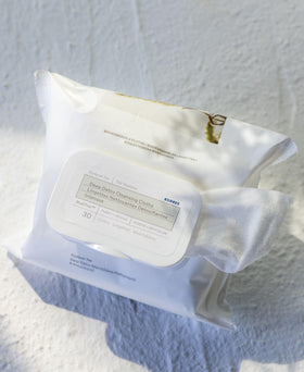 KORRES wipe in hand removing makeup, showing quick cleansing benefit