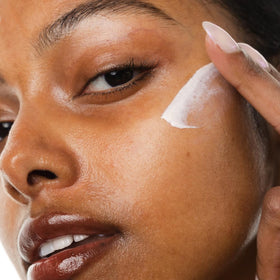 KORRES travel-size tube in a makeup bag signaling portability and on-the-go reapplication