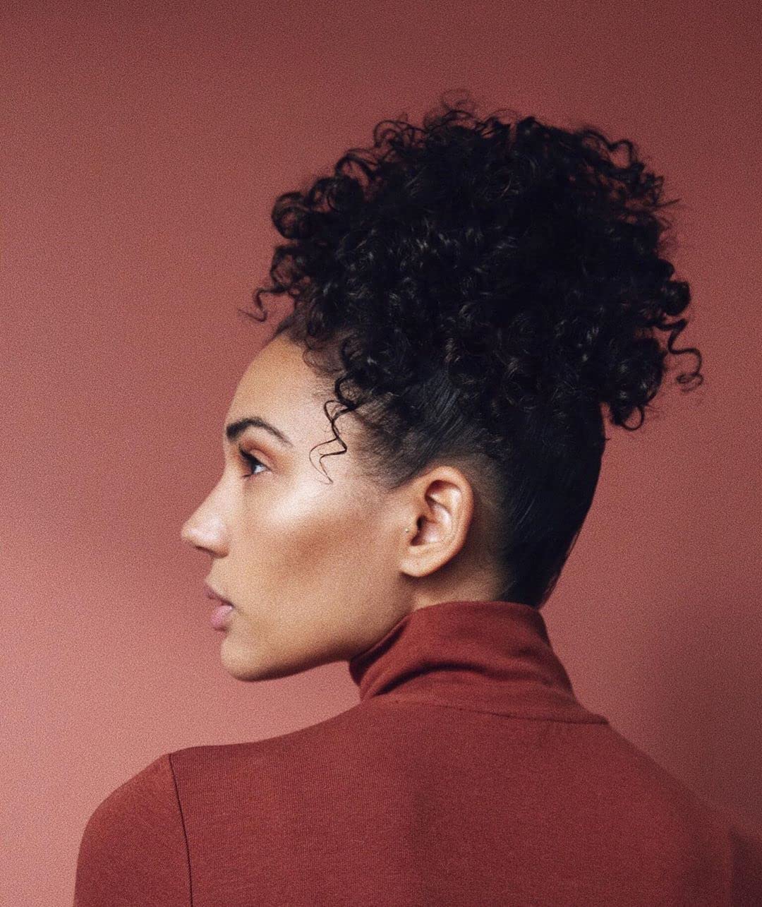 Kristin Ess in‑shower use on wet curls demonstrating frizz reduction benefit