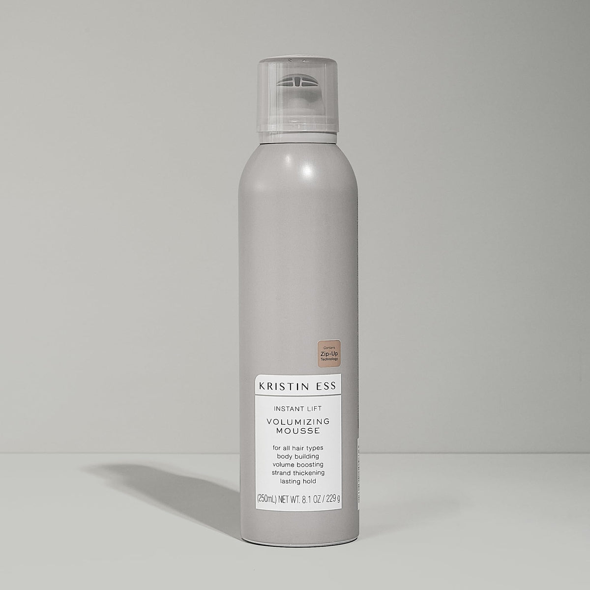 Kristin Ess 8.1 oz bottle next to hand showing compact size benefit