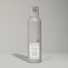 Kristin Ess 8.1 oz bottle next to hand showing compact size benefit