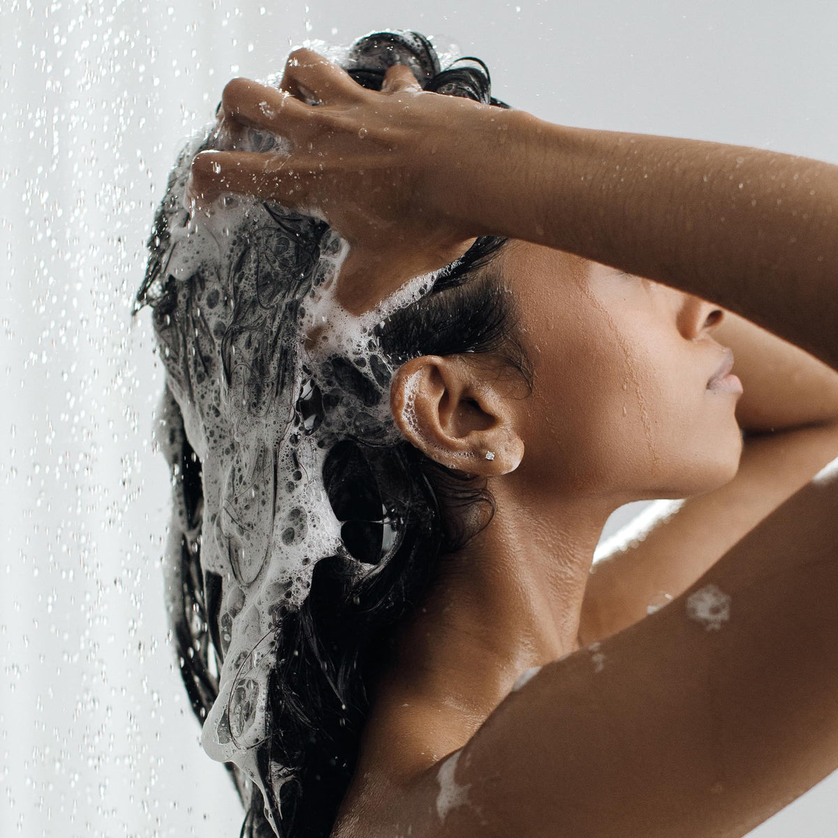 Kristin Ess shampoo in shower showing in-use cleansing benefit for scalp detox