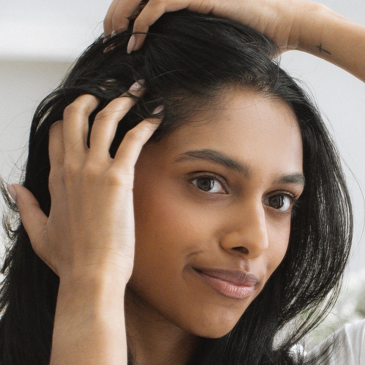 Close-up of Kristin Ess powder texture illustrating lightweight blendability and volume benefit