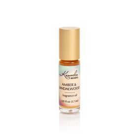 Kuumba Made front packaging showing compact amber and sandalwood roller for portability
