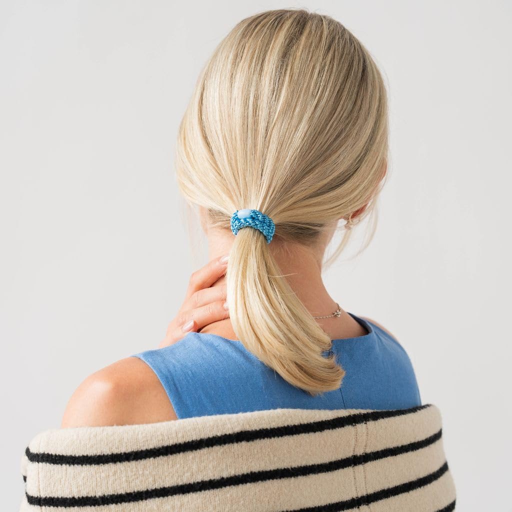 L. Erickson hair tie beside coin showing compact size and travel-friendly benefit