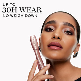 Lancôme mascara next to coin for size comparison and travel-friendly convenience