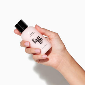 L'ANGE HAIR 4 fl oz next to a ruler to show compact travel-friendly size benefit