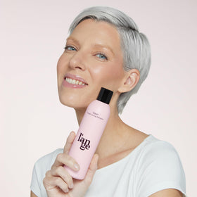 L'ANGE HAIR bottle held in hand to show actual size and travel-friendly benefit
