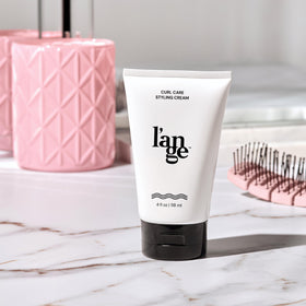 L'ANGE HAIR lifestyle bathroom sink scene suggests daily styling routine