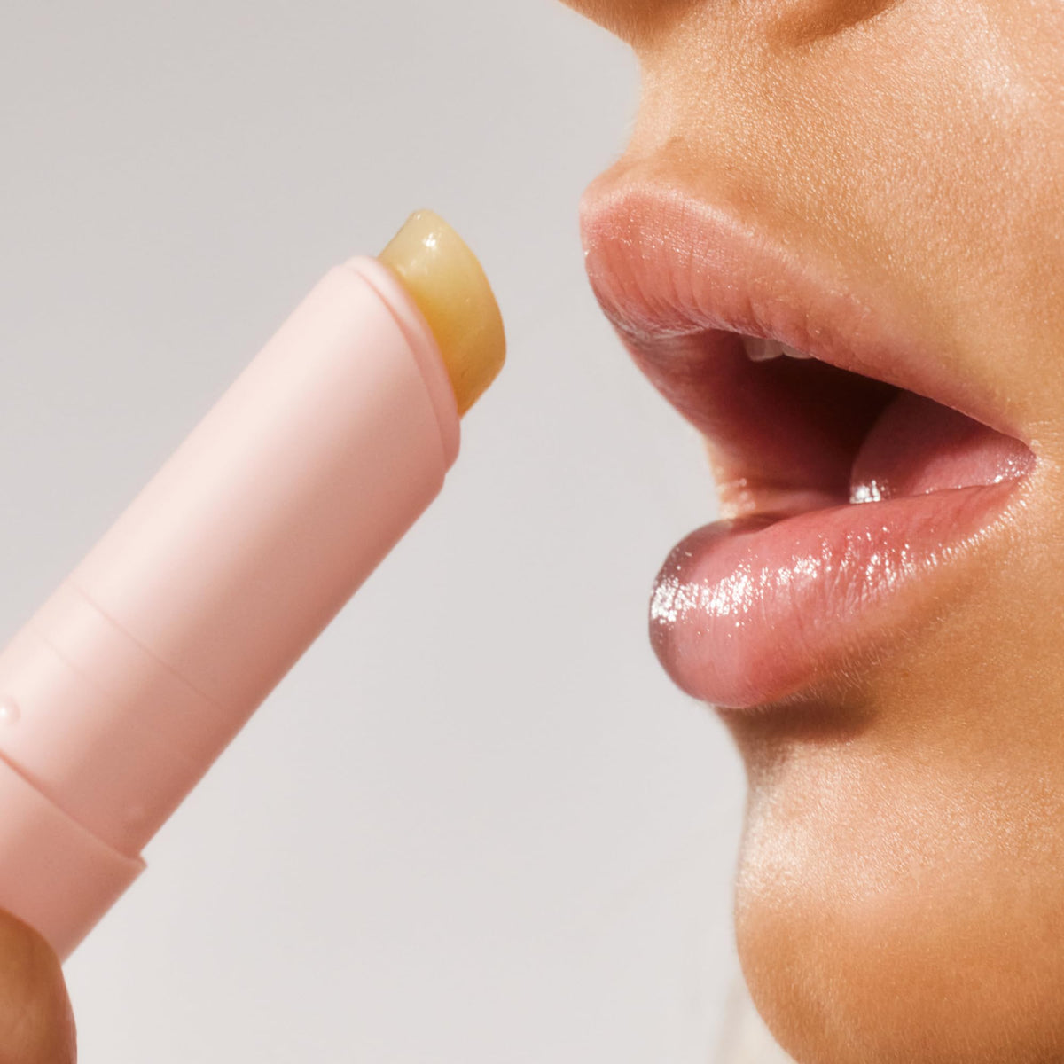 Lanolips Lanostick held beside a coin showing the 3.3g compact travel-friendly size