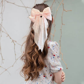 LAPOHI bow worn in ponytail adding instant feminine flair and color