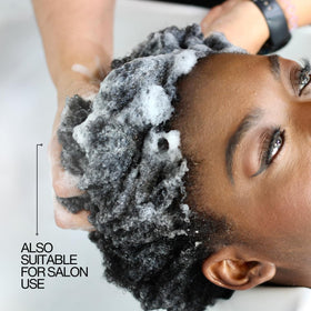 Lasio shampoo in hand during application showing easy rinsing benefit