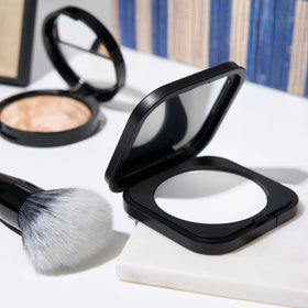 LAURA GELLER NEW YORK makeup brush applying powder for even oil-control finish