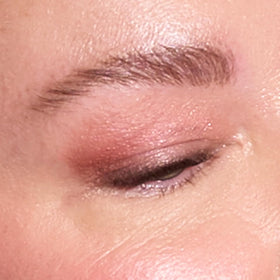 LAURA GELLER mature-skin model applying primer under eye showing softened lines and luminous finish