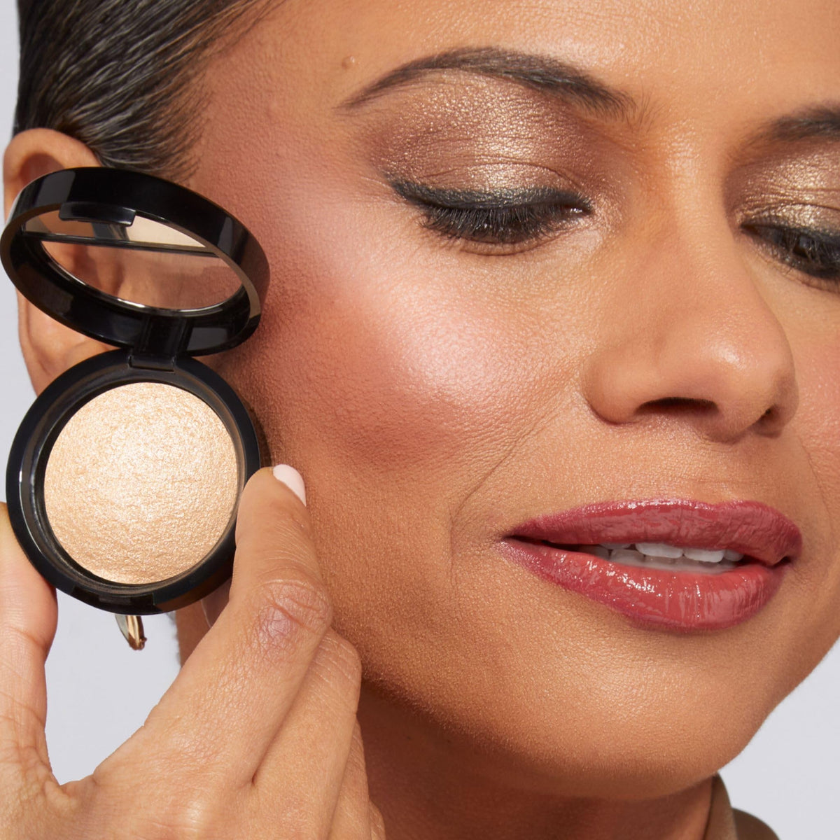 LAURA GELLER Portofino compact open in hand showing size for travel convenience