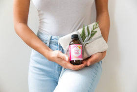 Leven Rose 4 oz bottle held in hand to show true size and portability