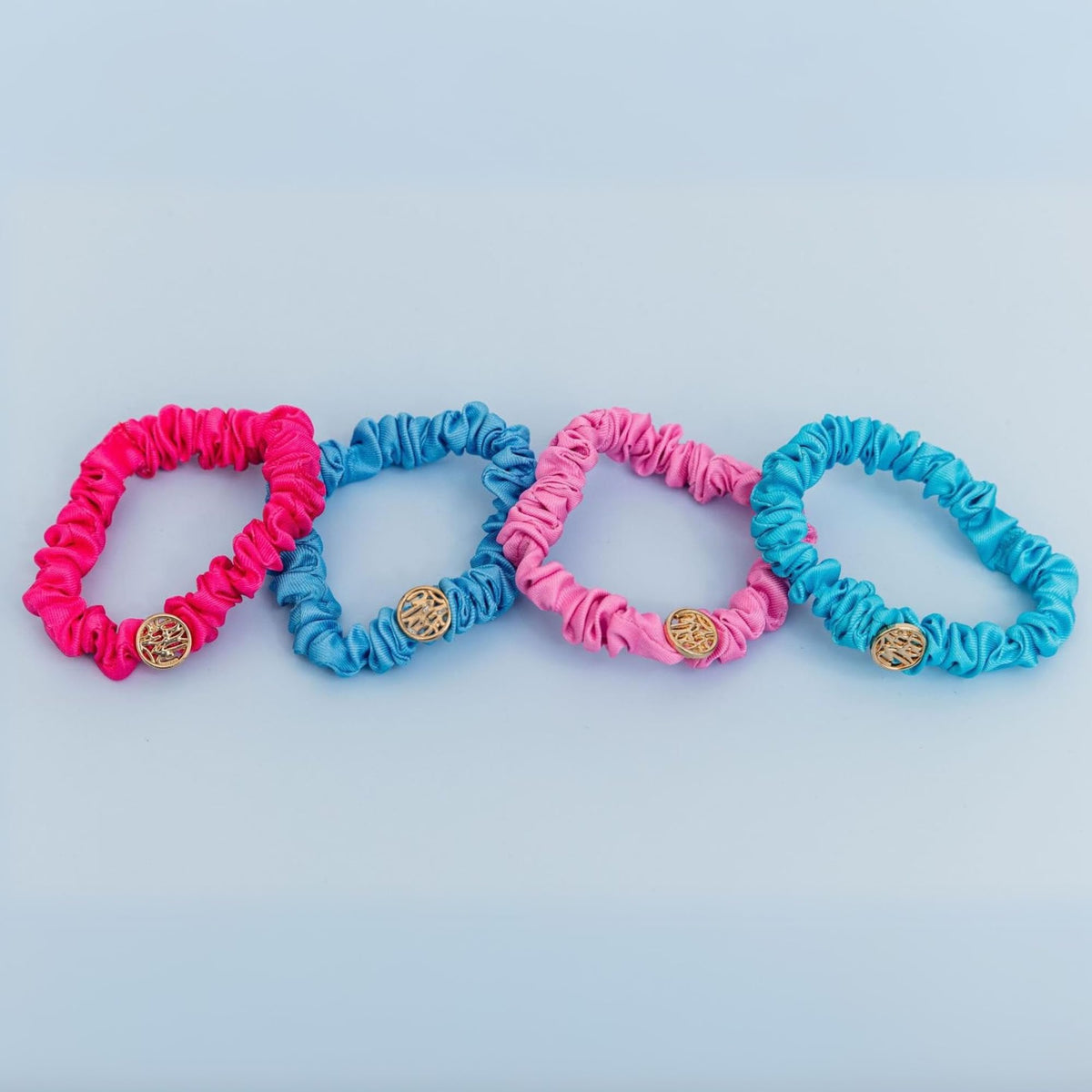 Lilly Pulitzer gold logo charm detail on scrunchie adding a polished accent