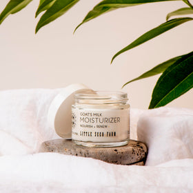 Little Seed Farm jar held in hand showing 2.0 oz travel-friendly size
