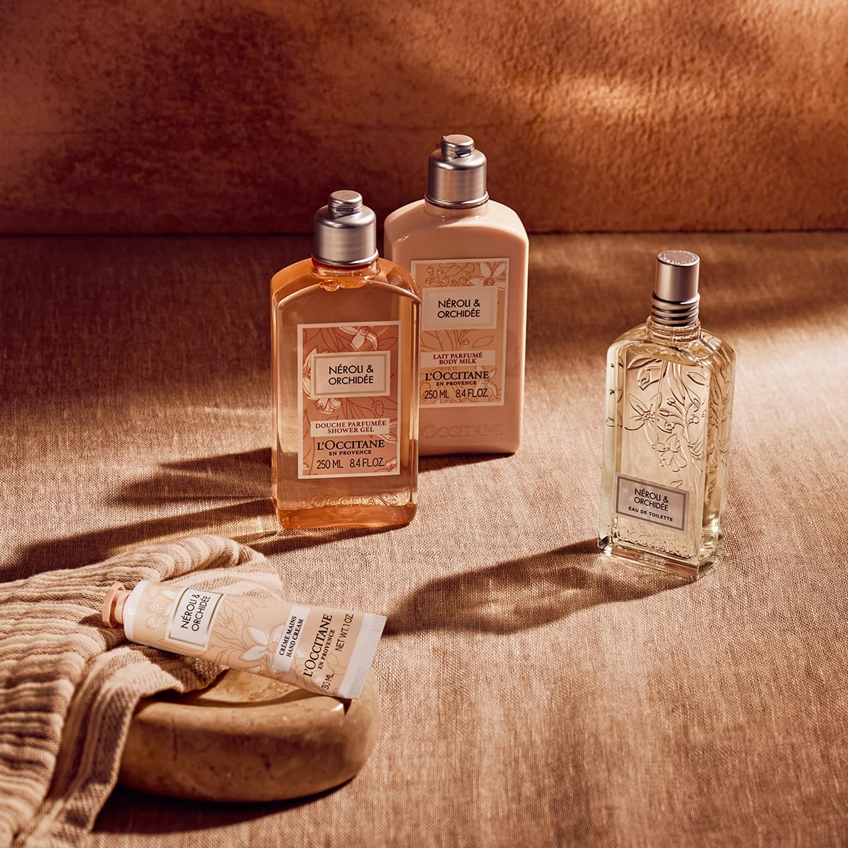 L'OCCITANE on a shower shelf styled with towels to show daily routine fit