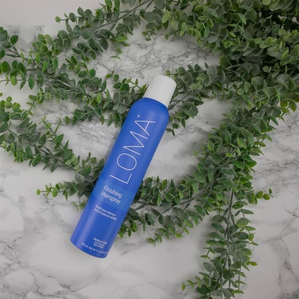 Loma finishing hairspray 9.1 oz held in hand showing scale and travel-friendly convenience