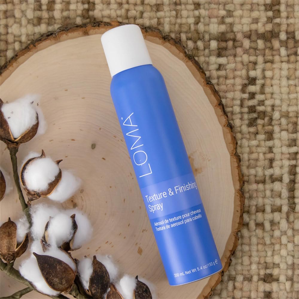 Loma bottle held in hand to show 5.4 oz scale and travel-friendly styling convenience