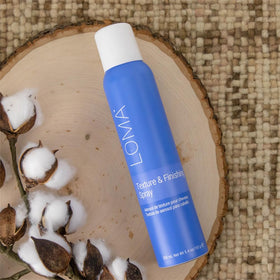 Loma bottle held in hand to show 5.4 oz scale and travel-friendly styling convenience
