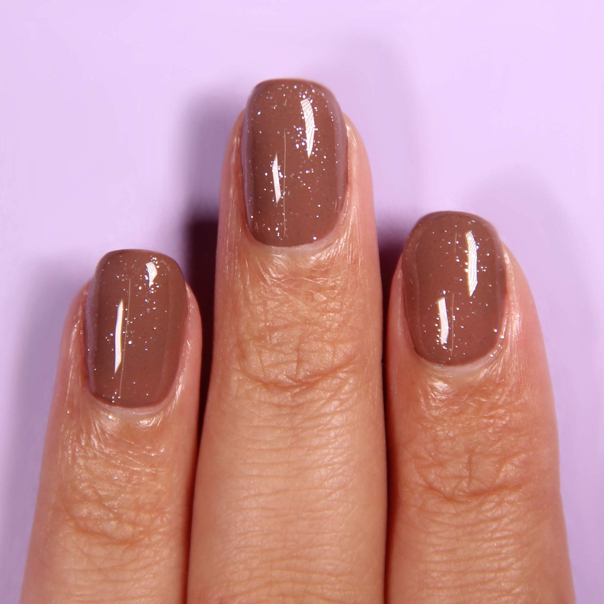 LONDONTOWN top coat on manicured hands adding iridescent depth and long-lasting shine