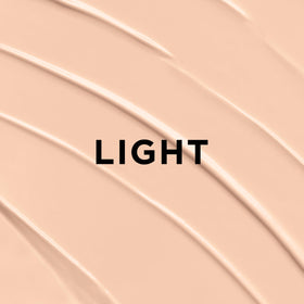 L'Oreal Paris BB cream on a vanity with brush and vitamins for daily routine