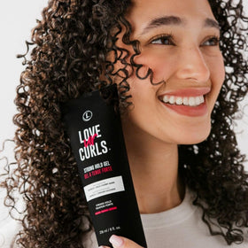 Love Ur Curls gel being smoothed into wet hair for even distribution