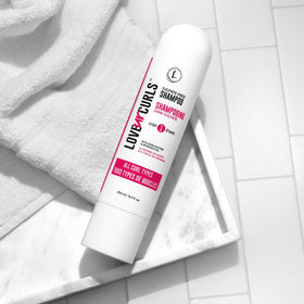 Love Ur Curls bottle in hand for size comparison and travel-friendly benefit