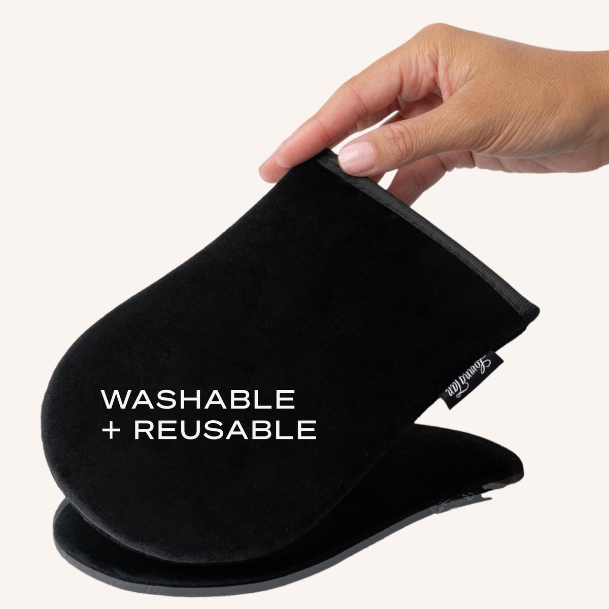 Loving Tan mitt being rinsed under water illustrating easy cleaning for reusable, eco-friendly use