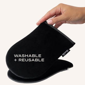 Loving Tan mitt being rinsed under water illustrating easy cleaning for reusable, eco-friendly use