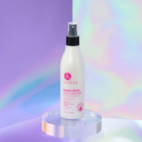 L LUSETA bottle next to hand to show true 8.5oz scale and travel convenience