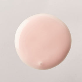 Luster's pink oil moisturizer applied in hand demonstrating smooth application