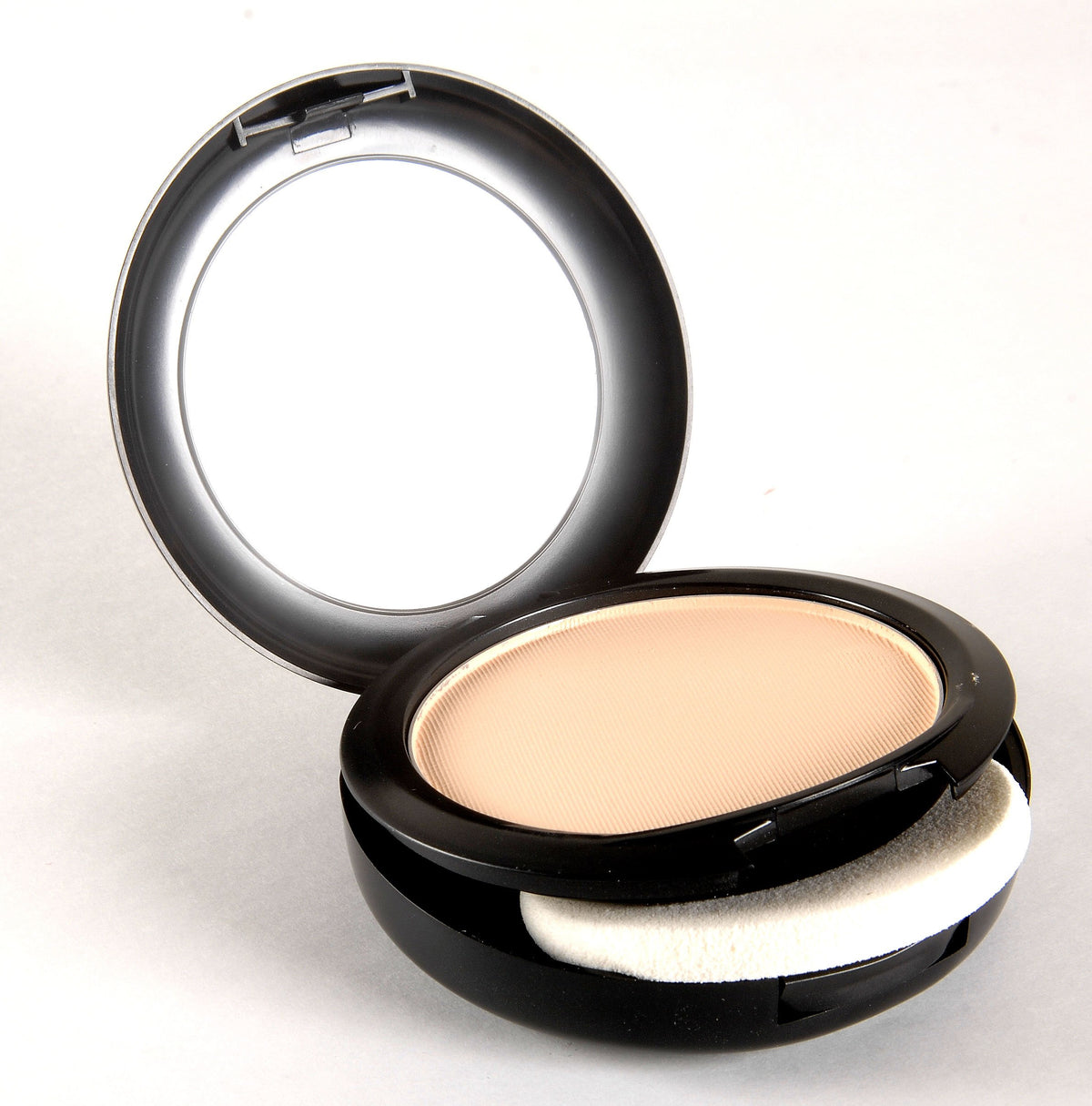 MAC Studio Fix in a makeup bag lifestyle scene showing portability and on-the-go touch-ups