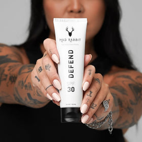 Mad Rabbit applying sunscreen on arm to protect tattoo and skin