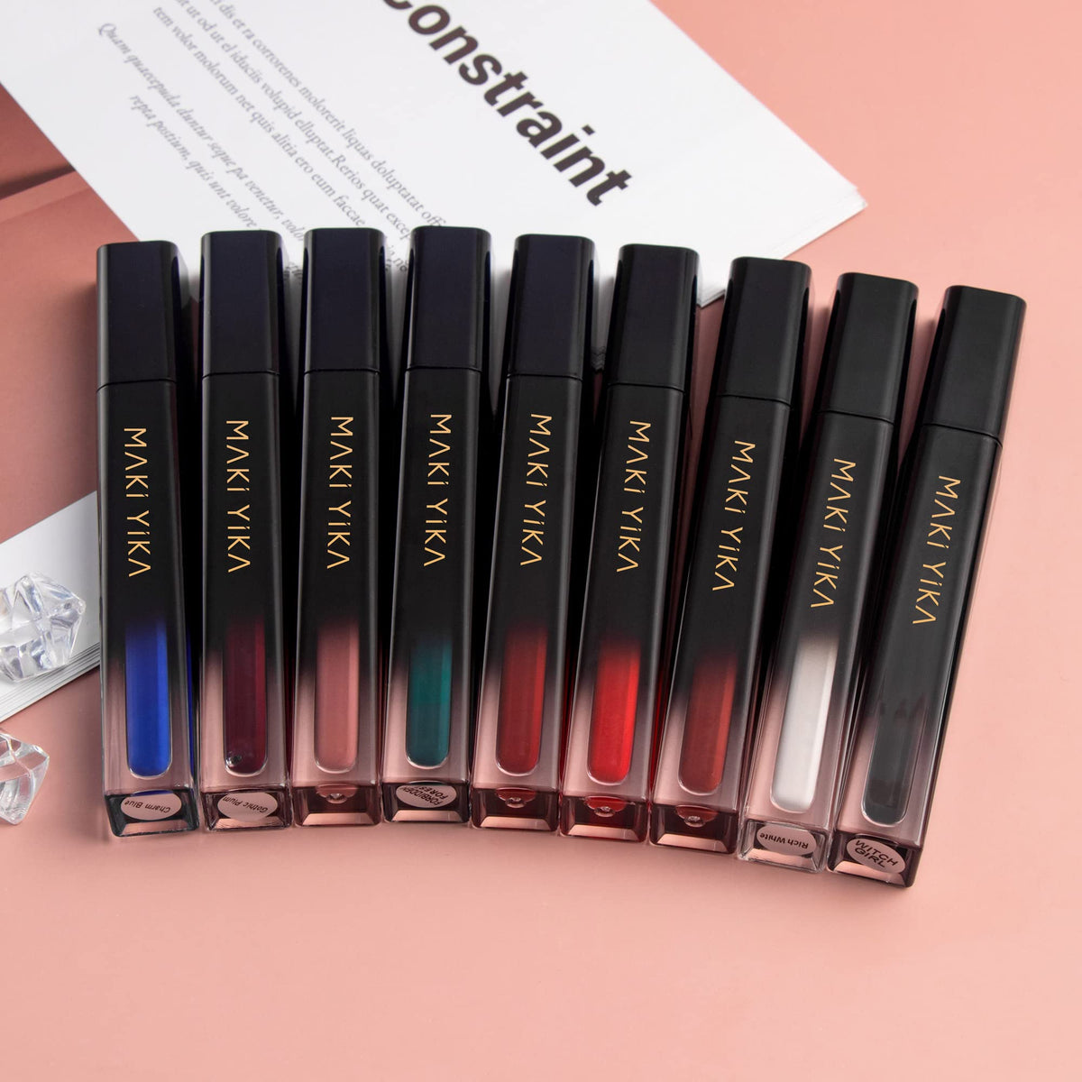 MAKI YIKA lipstick next to a coin showing compact tube size for travel convenience
