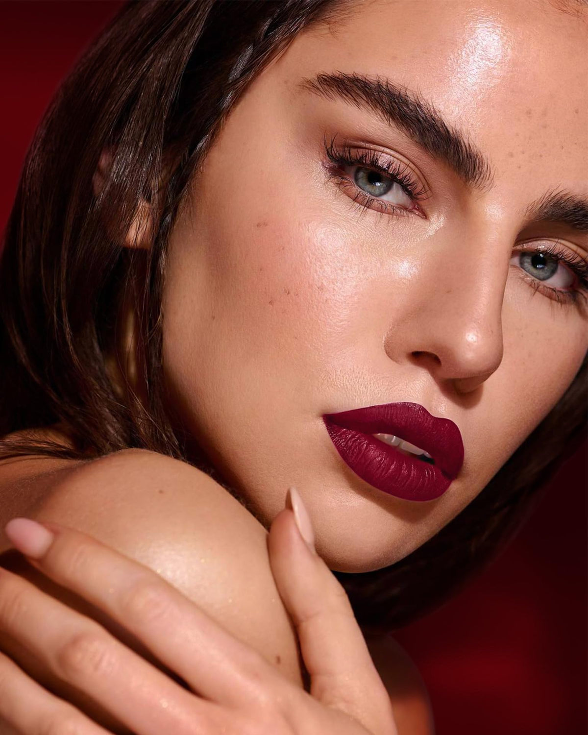 MAKI YIKA on-model lips in use showing even burgundy application and lasting wear
