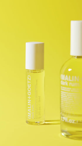 MALIN+GOETZ Dark Rum box with ingredient list flatlay emphasizing clean formula and travel-ready packaging