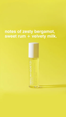 MALIN+GOETZ Dark Rum rollerball held in hand to show scale and ease of pocketable portability