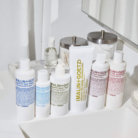 MALIN+GOETZ ingredients arranged to show grapefruit extract and amino acids for gentle efficacy benefit