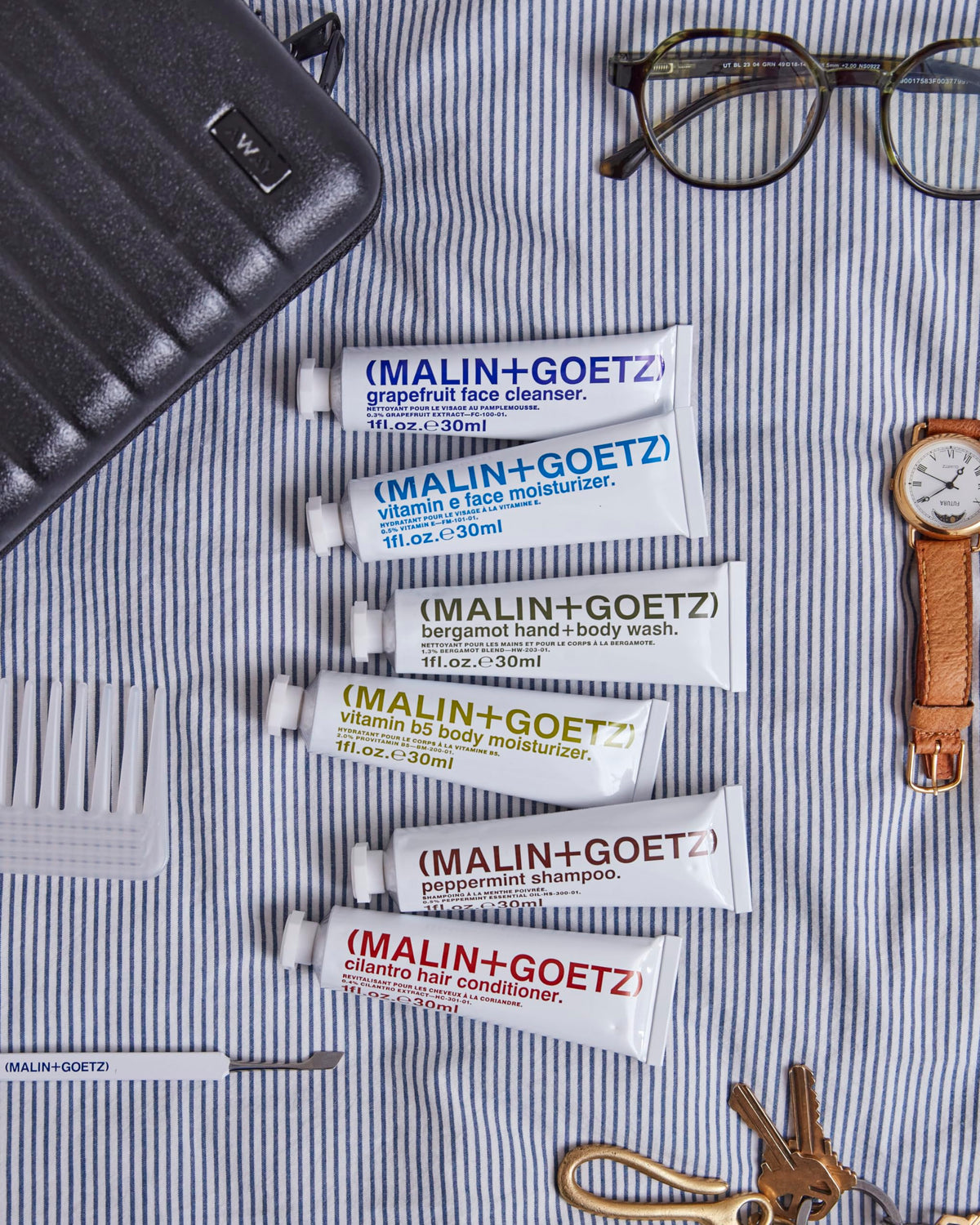 MALIN+GOETZ products staged in a hotel bathroom showing routine-ready convenience