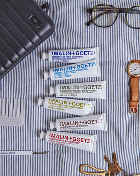 MALIN+GOETZ products staged in a hotel bathroom showing routine-ready convenience
