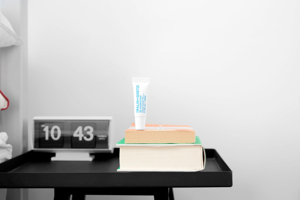 MALIN+GOETZ application on lips in everyday setting illustrating long-lasting protection