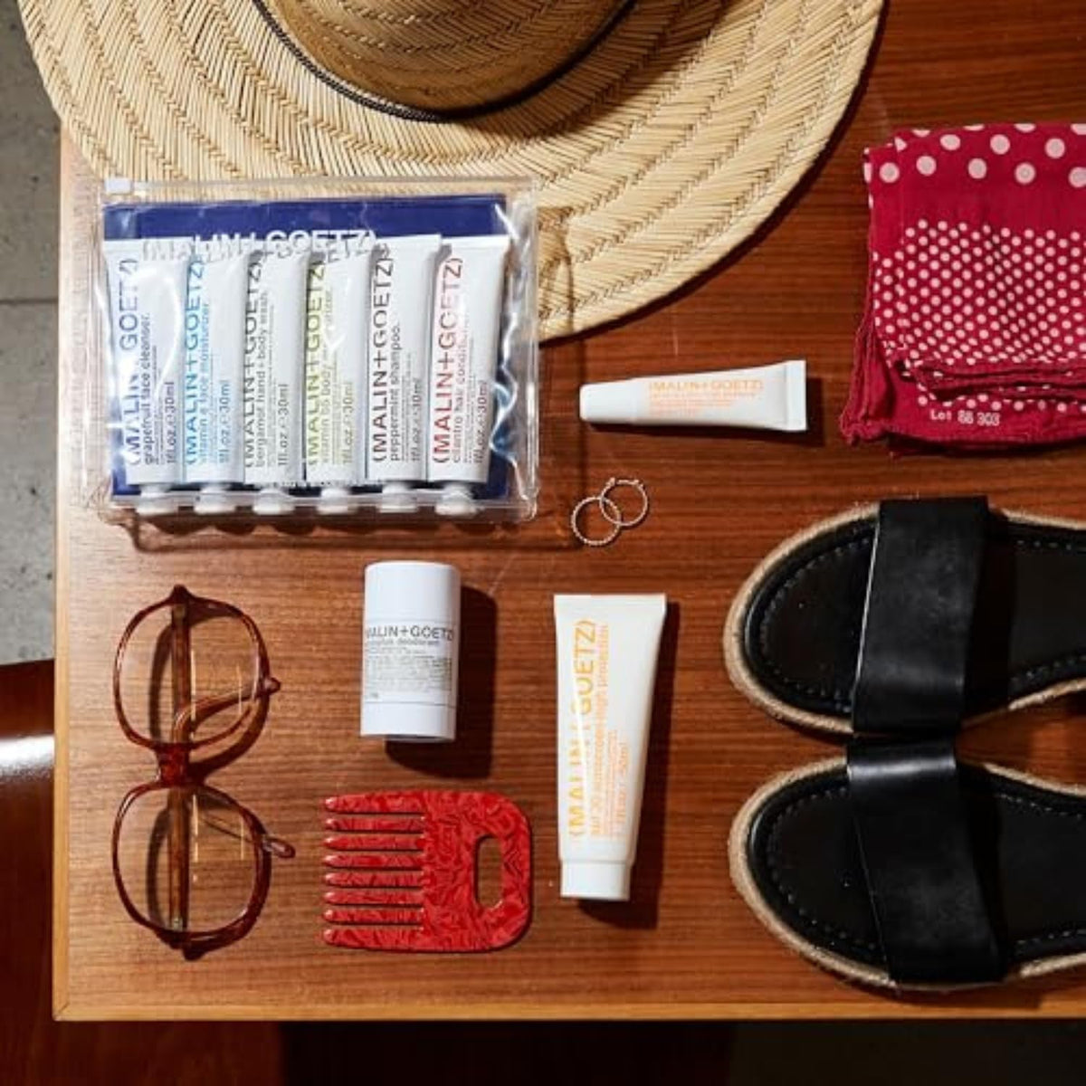 MALIN+GOETZ sunscreen in outdoor beach setting demonstrating reef-safe formula and water resistance