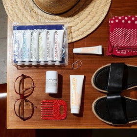 MALIN+GOETZ sunscreen in outdoor beach setting demonstrating reef-safe formula and water resistance